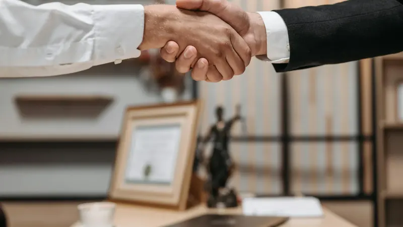 Client and lawyer shaking hands after signing